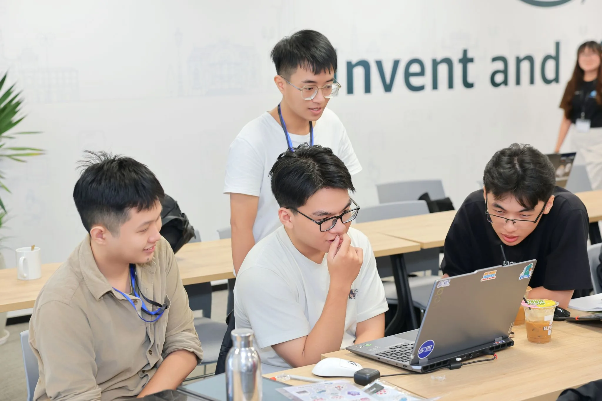 Four engineers working through an investigation together on one laptop